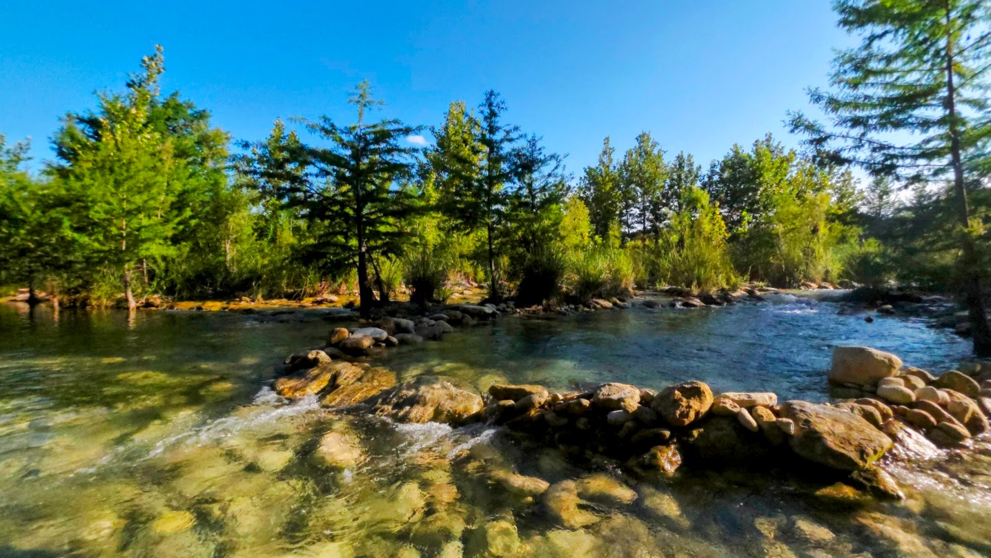 On the banks of the Frio River. Water moving over smooth river rocks